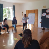 Trainerin Denise Lee spricht vor der Gruppe