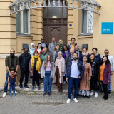 The participants of the network meeting stand in front of the entrance of the EJBW. 