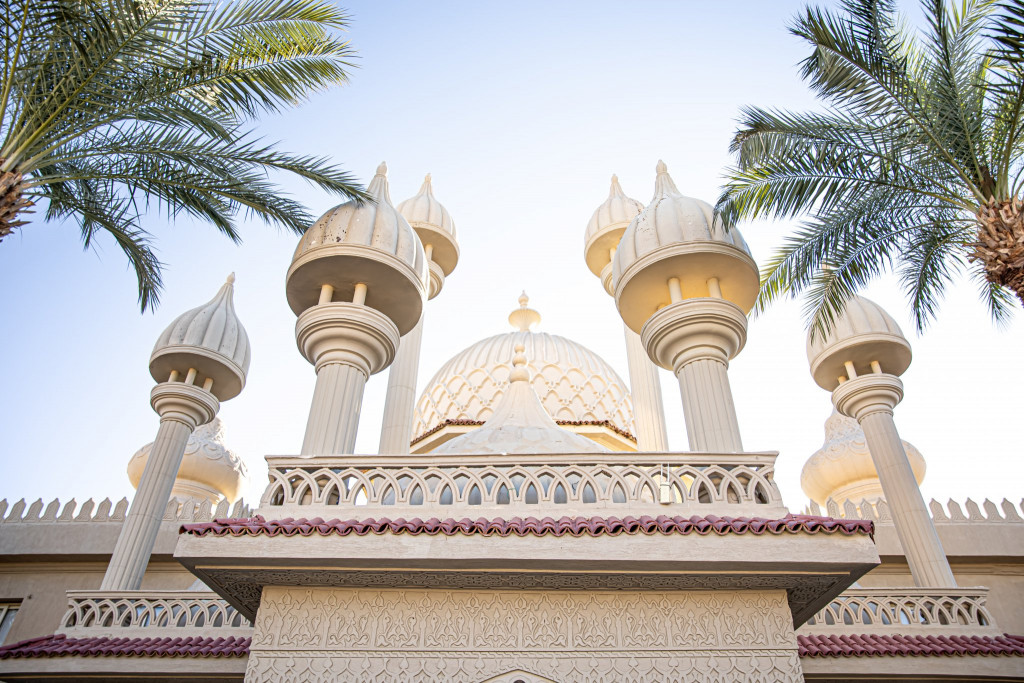 Traditional Islamic mosque under palm trees in sunny weather (Image by pvproductions on Freepik)