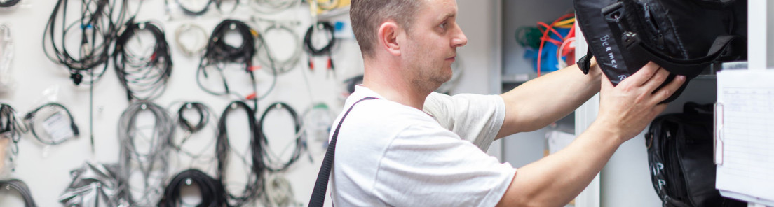 Der Hausmeister bereitet die Technik für ein Seminar vor
